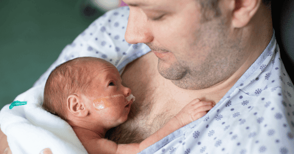 a man holding his baby in in a hospital setting